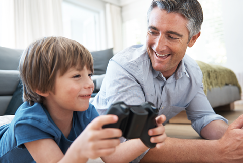 Father watching son play video game with a bluetooth controller