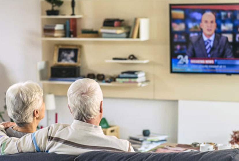 Older couple watching TV on a couch